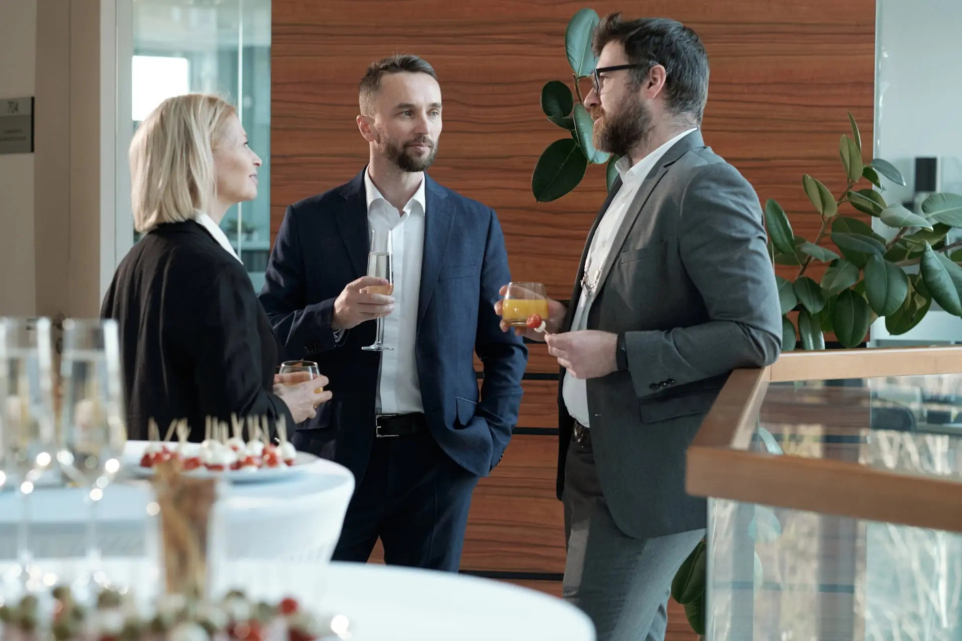 Convives avec champagne ou jus, pièces cocktail à portée de main
