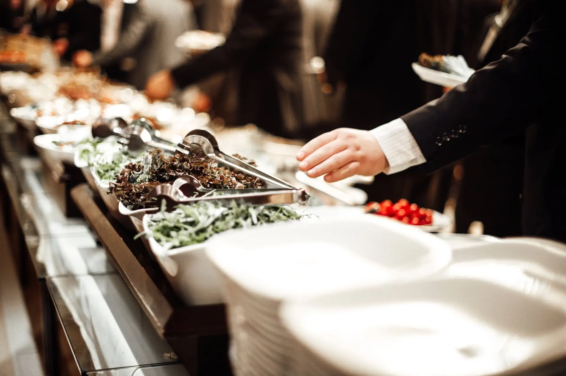 Buffet d'entreprise avec salades, assiettes et service en file